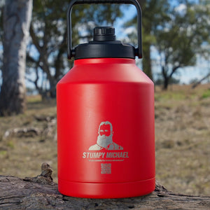 Red Stumpy Michael water bottle on a log with trees in the background